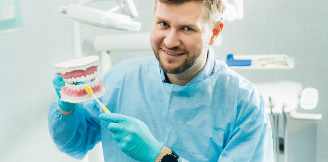 dentist demonstrating how to brush teeth