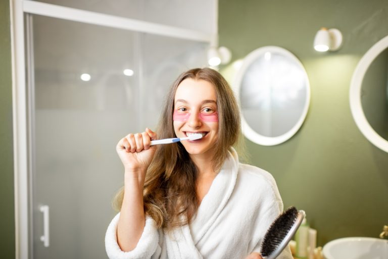 teeth care demonstrated by a white woman brushing her teeth