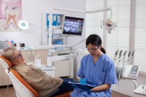 Dental assistant completing questionnaire to make sure that any possible other health issues can be identified during the Cheadle dental appointment