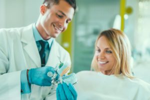 dentist showing his patient a mould of her teeth in a cosmetic dentists appointment