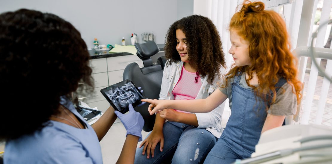 two young girls looking at dental x-ray during a paediatric dentistry appointment